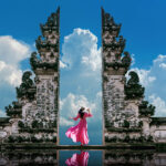A female with a pink dress standing at Temple gates at Lempuyang Luhur temple in Bali