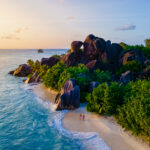 Anse Source d'Argent, La Digue Seychelles, a young couple of men and women on a tropical beach during a luxury vacation in Seychelles. Tropical beach Anse Source d'Argent, La Digue Seychelles