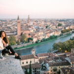 Young woman enjoying beautiful view on Verona city in Italy in the morning. Famous italian destination city of love. Film processing photo.